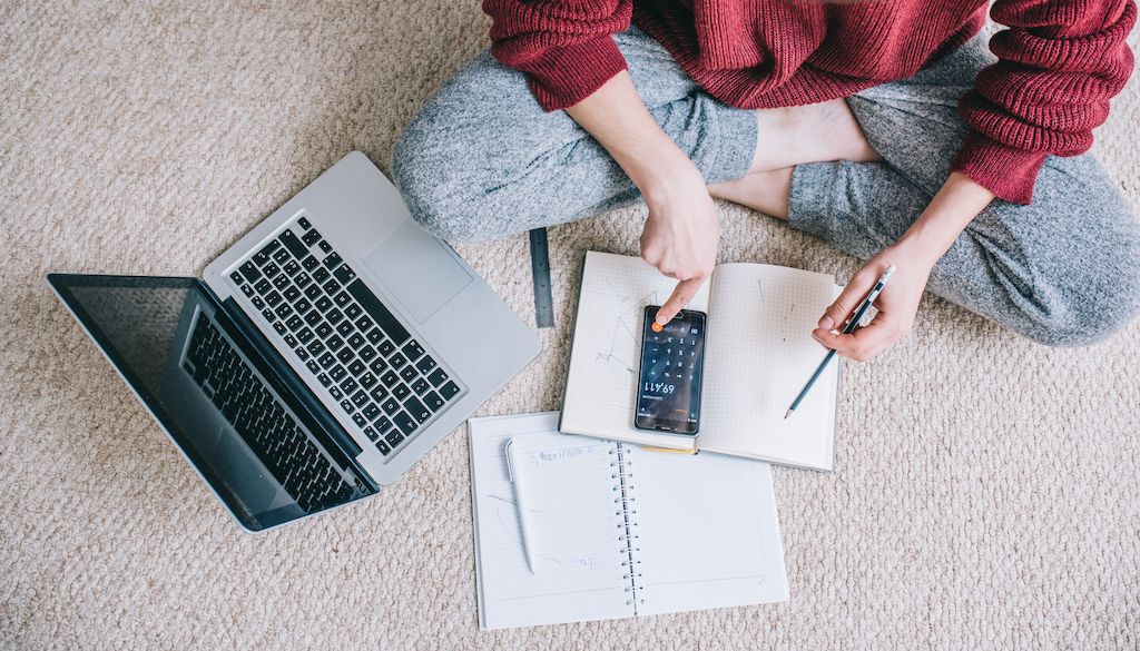 woman sitting on the floor making a budget