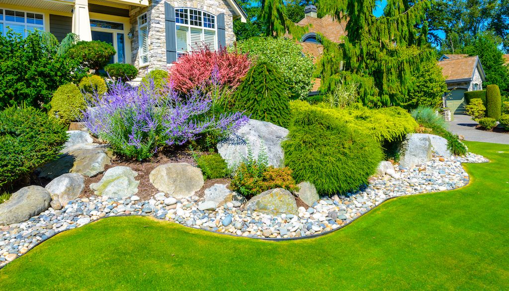 front yard landscape design with boulders and edging around garden