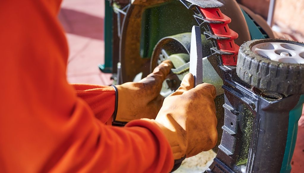 man sharpening lawnmower blades