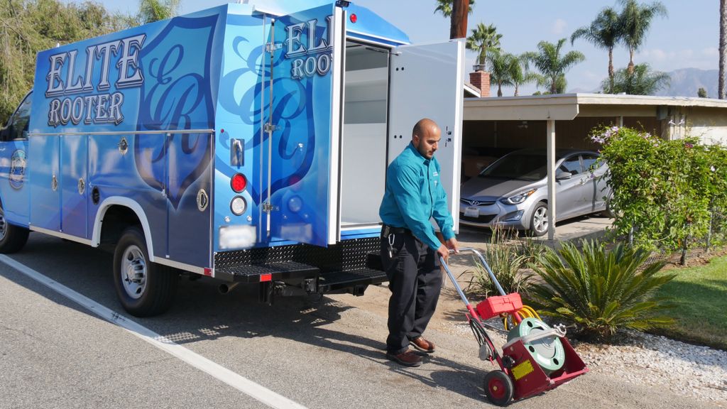  Elite Rooter technician loading mechanical snake 
