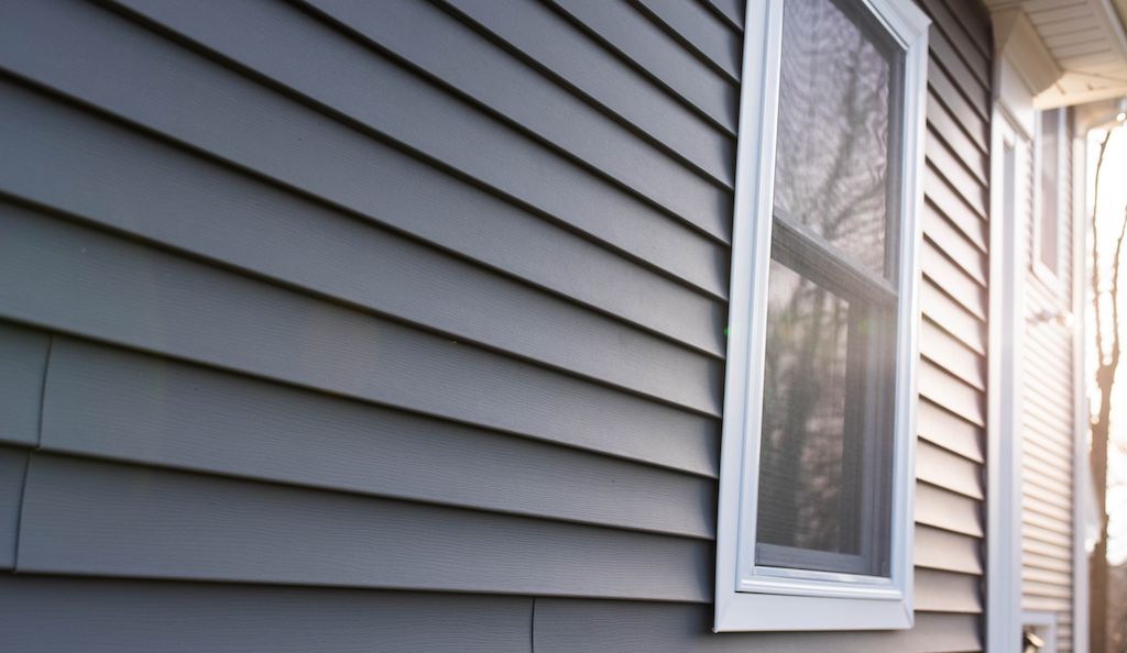 closeup up view of gray or blue vinyl siding on home