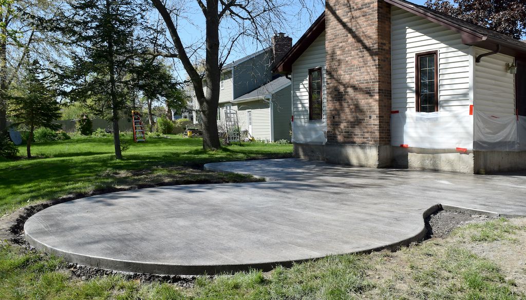 concrete patio construction in backyard of house