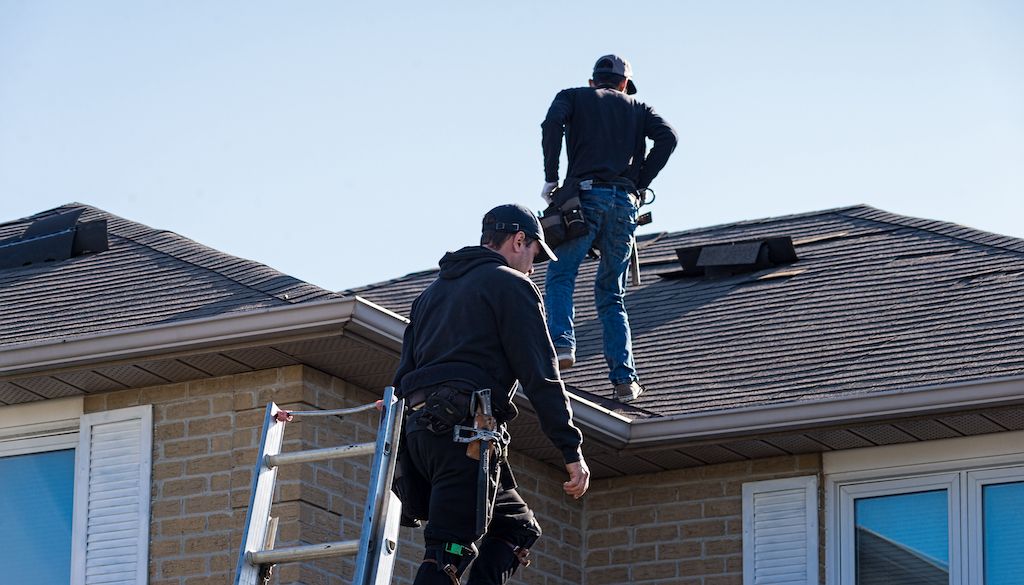 two contractors on top of roof