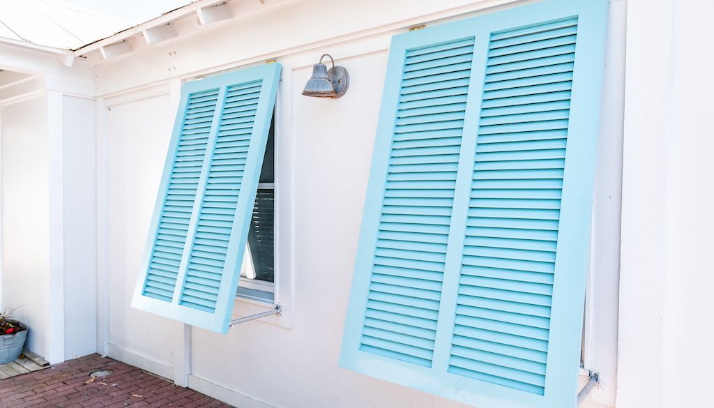 blue hurricane shutters on house