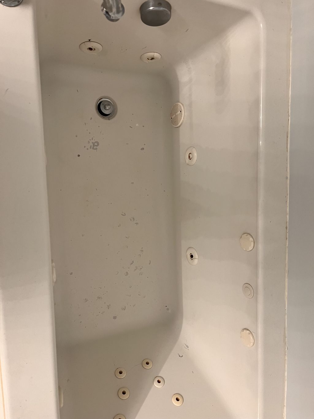 Before Jacuzzi tub with paint stuck to the bottom.