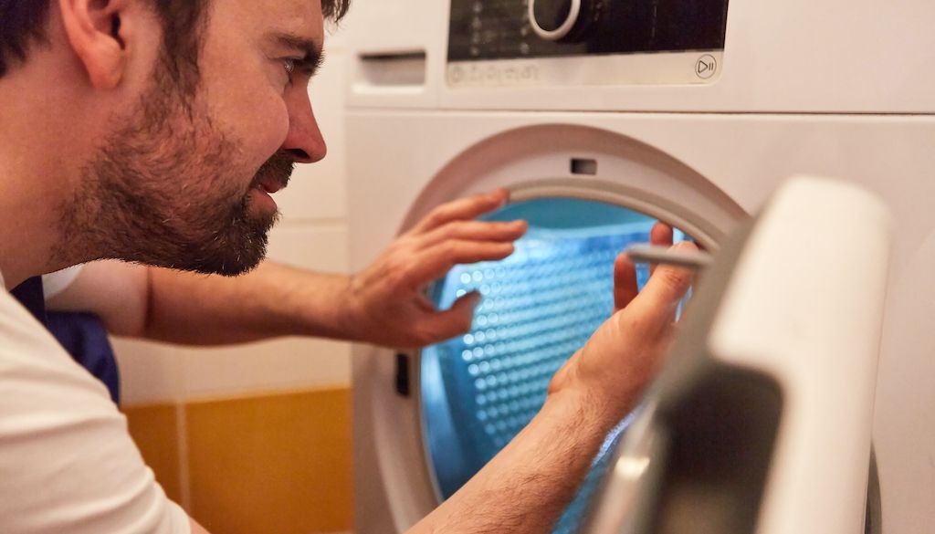 appliance repair technician fixing dryer door seal