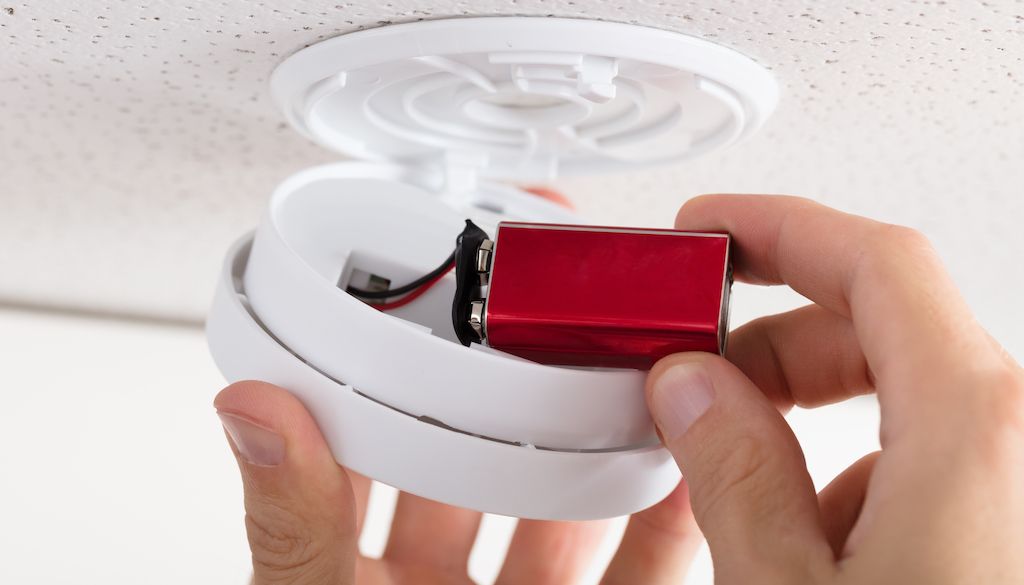changing batteries in home smoke detectors and alarm