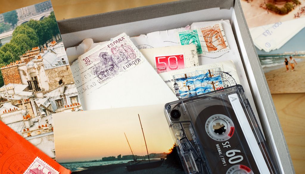 sentimental items, letters, postcards, tape, and photos in box