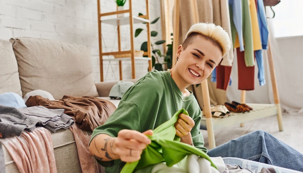 woman sorting through clothes and smiling