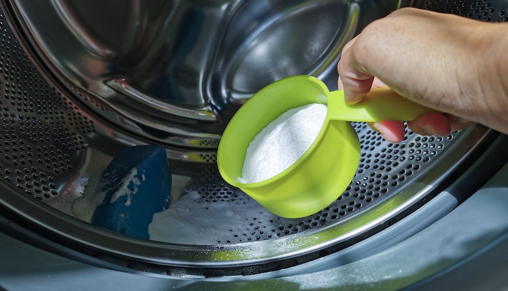 pouring baking soda into front load washer