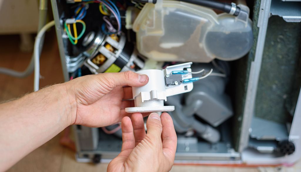 repair technician fixing dishwasher