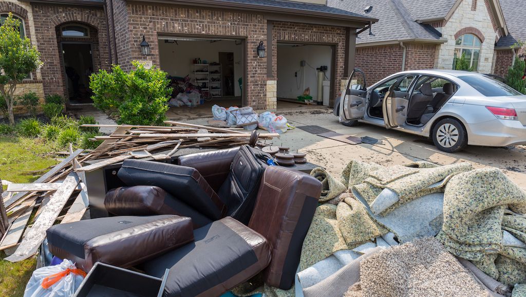 ruined furniture and belongings in front of houses in Houston suburb flooded from Hurricane Harvey 2017