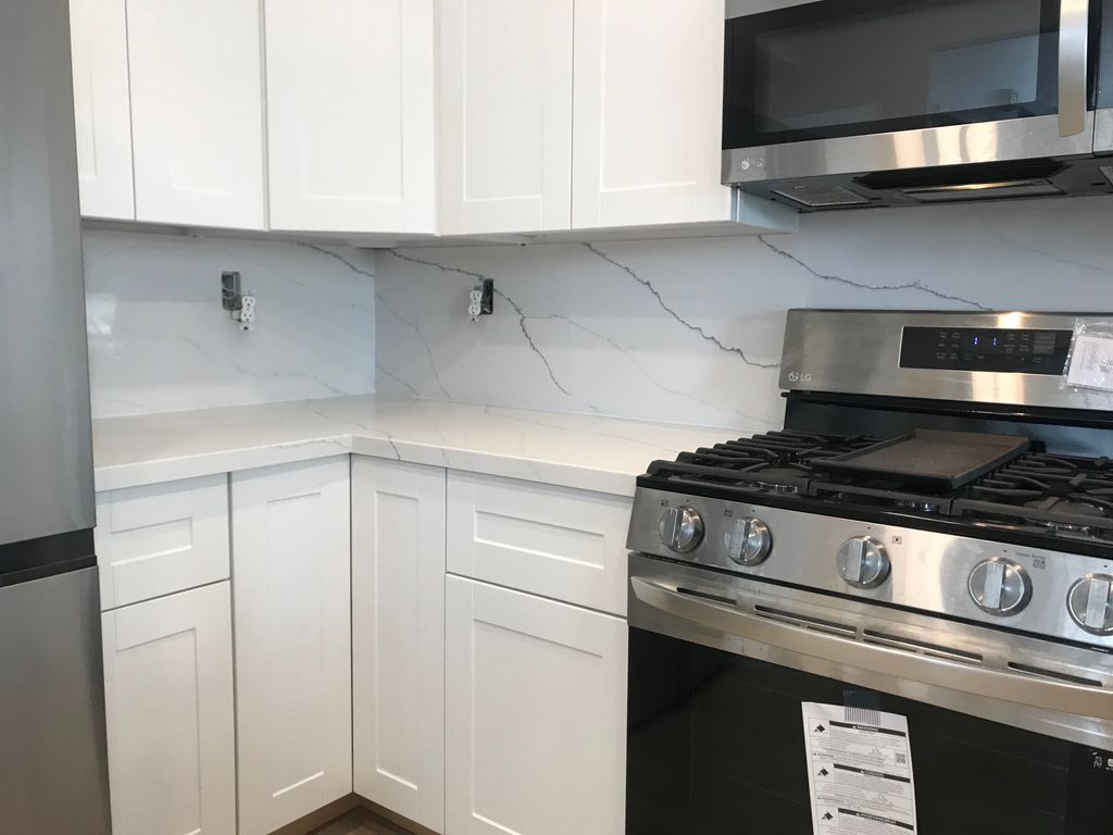 Quartz material kitchen installation with full bac