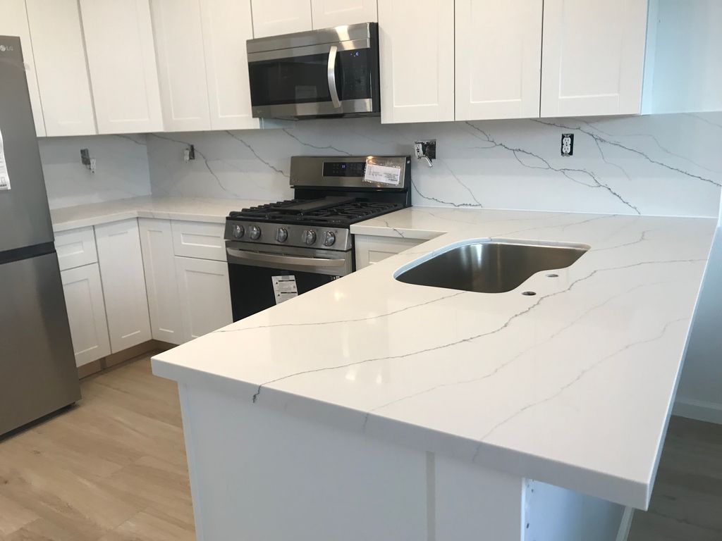 Quartz material kitchen installation with full bac