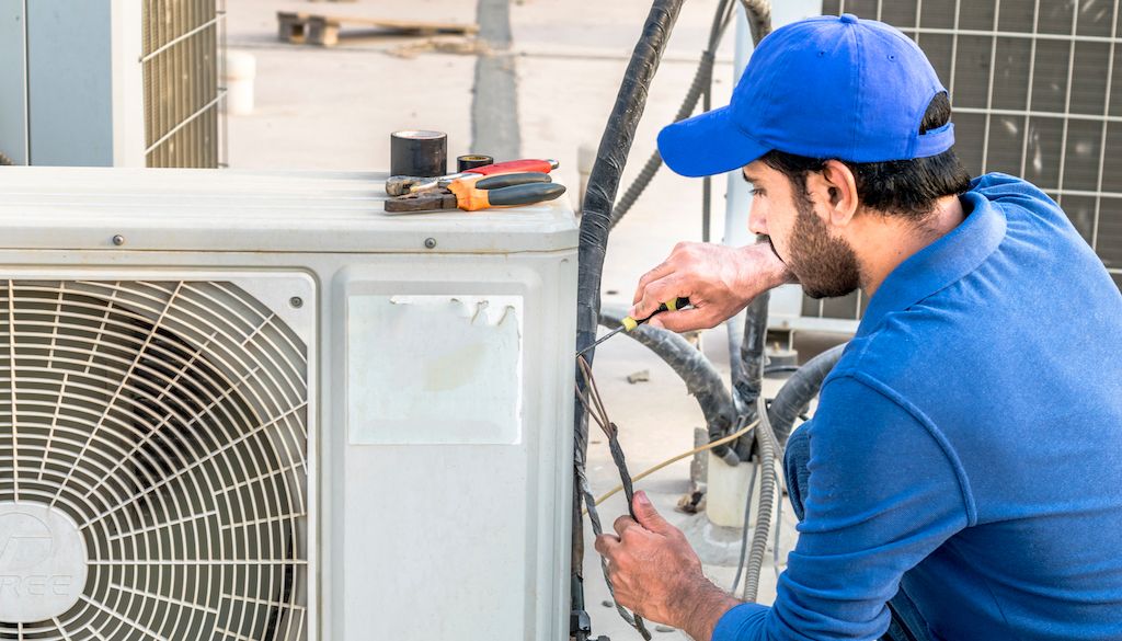 repairman fixing air conditioner