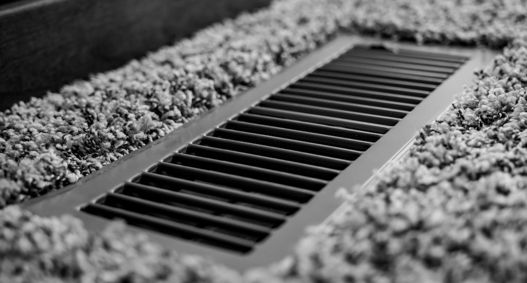 open vent in grey carpet flooring