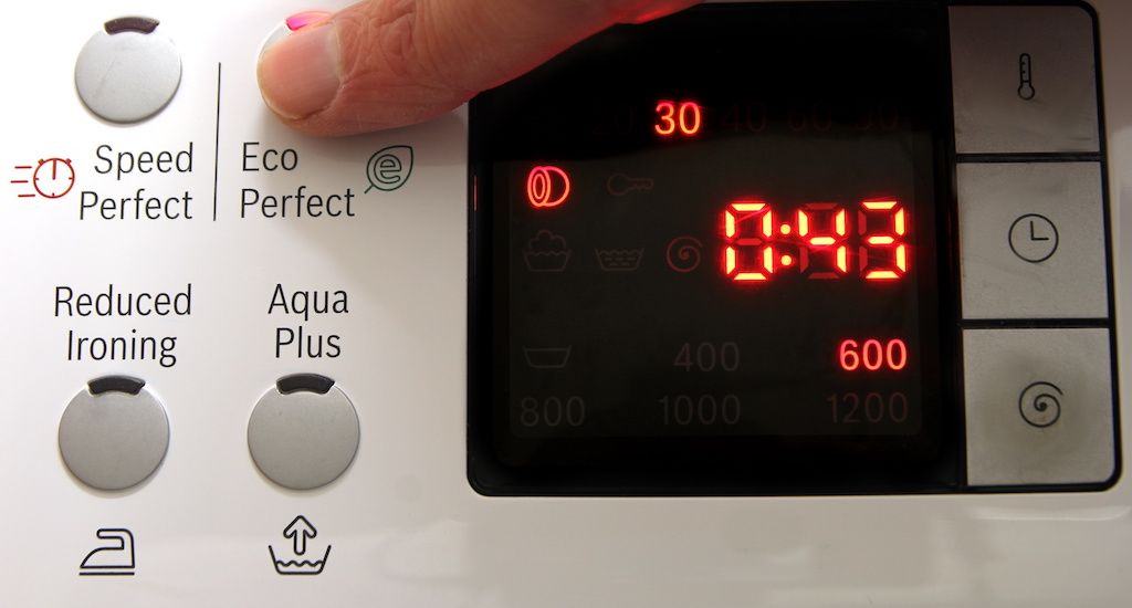 finger selecting eco-friendly energy saving option on washer