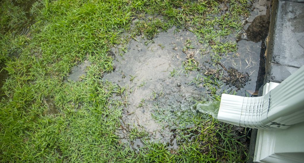 rainwater overflow from gutters near home foundation