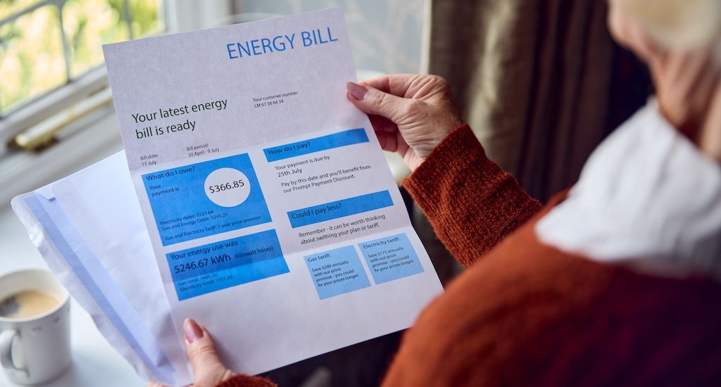 man reading high energy bill at home