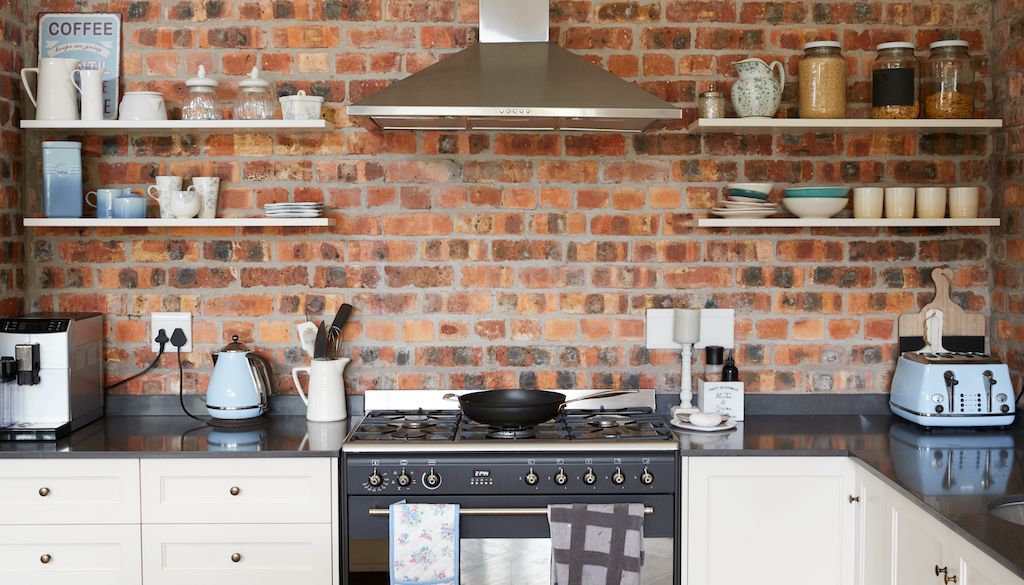 range in kitchen with brick wall