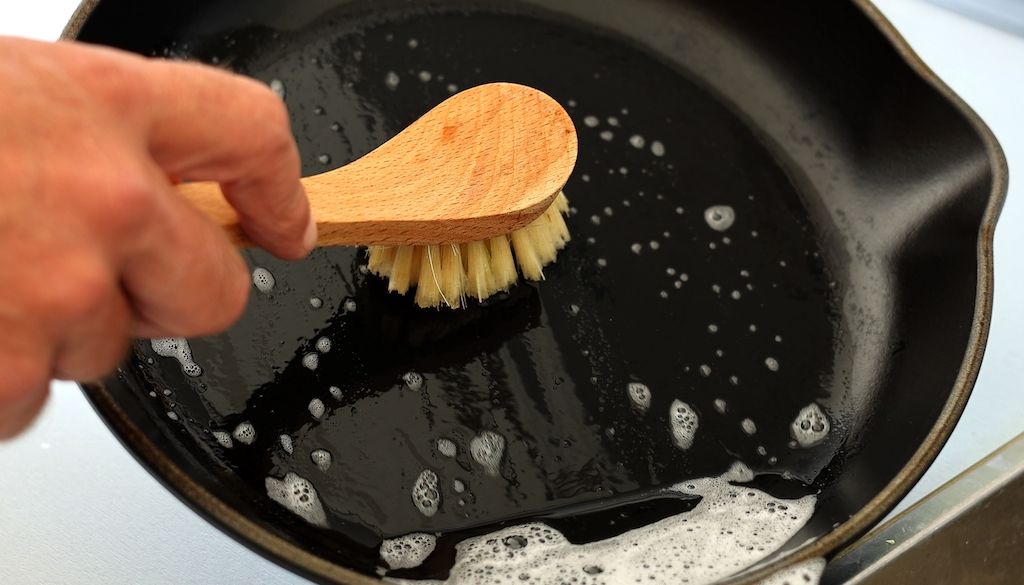 cleaning cast iron pan in sink