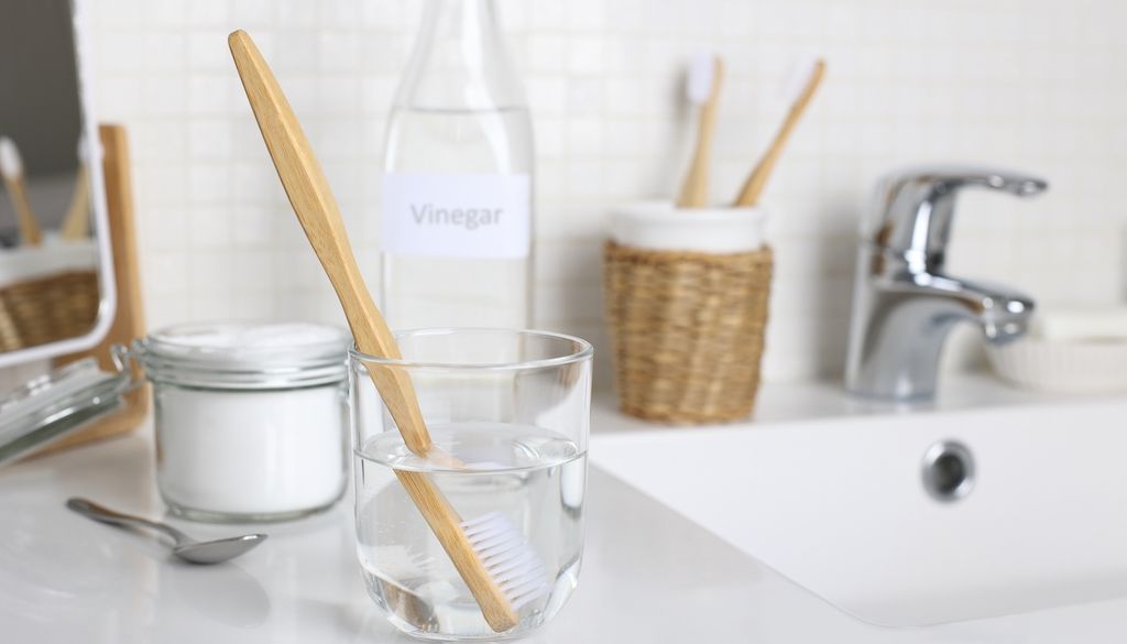 bottle and jar of distilled white vinegar and baking soda on counter