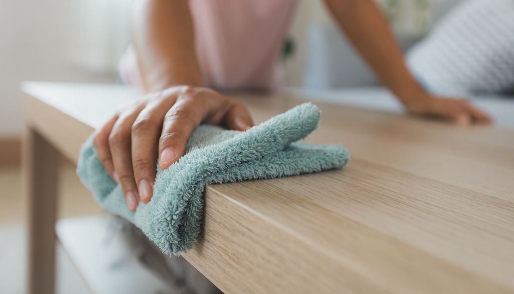 wiping down table with microfiber cloth