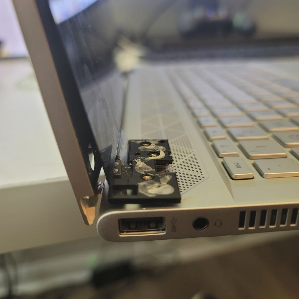 HP laptop with a protruding broken hinge, pre-repa