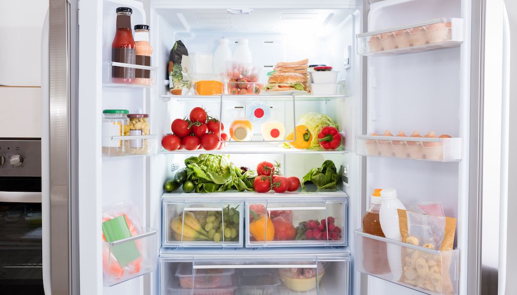 large open fridge with fresh food inside