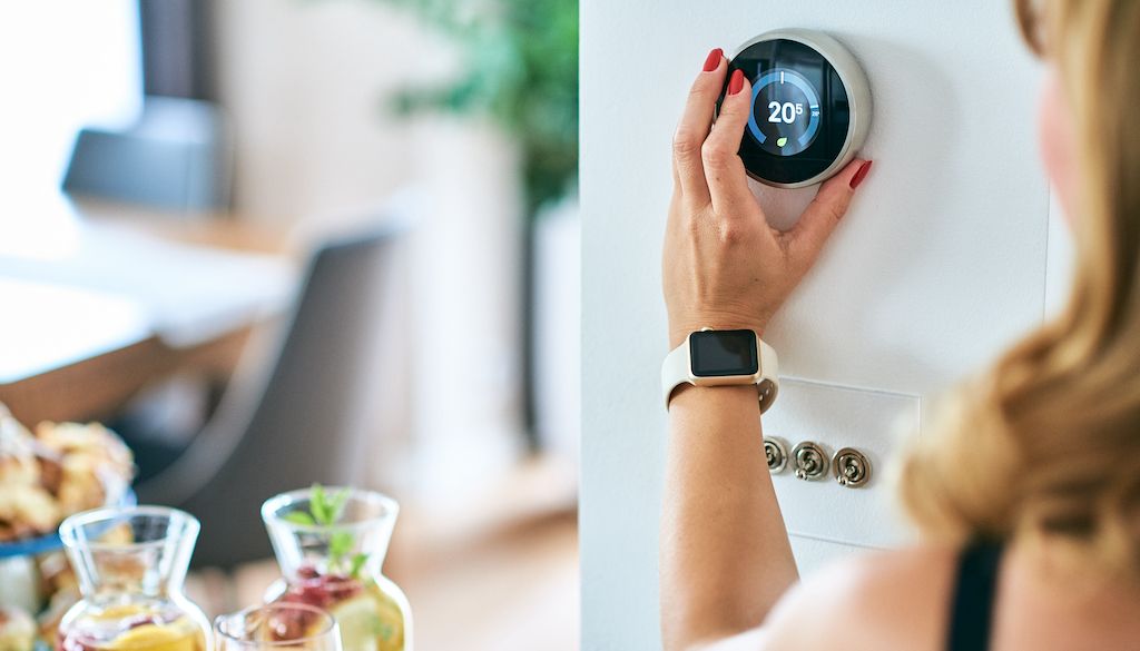 woman adjusting thermostat