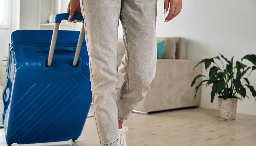 person pulling suitcase in home