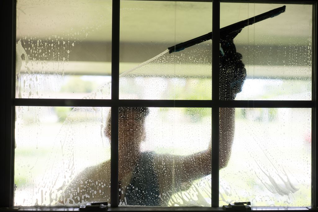 Using traditional window cleaning tools.