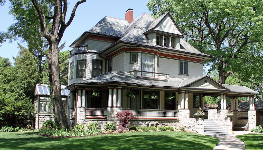 historic home with green lawn and trees