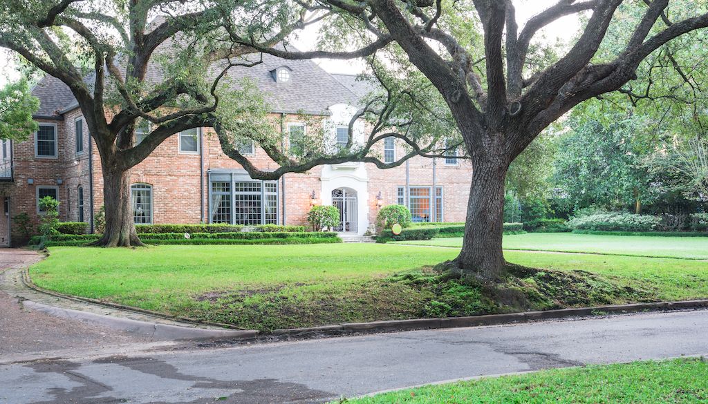 big oak trees in front of historic colonial home