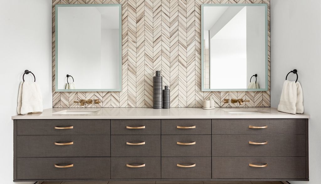bathroom vanity with herringbone tile backsplash