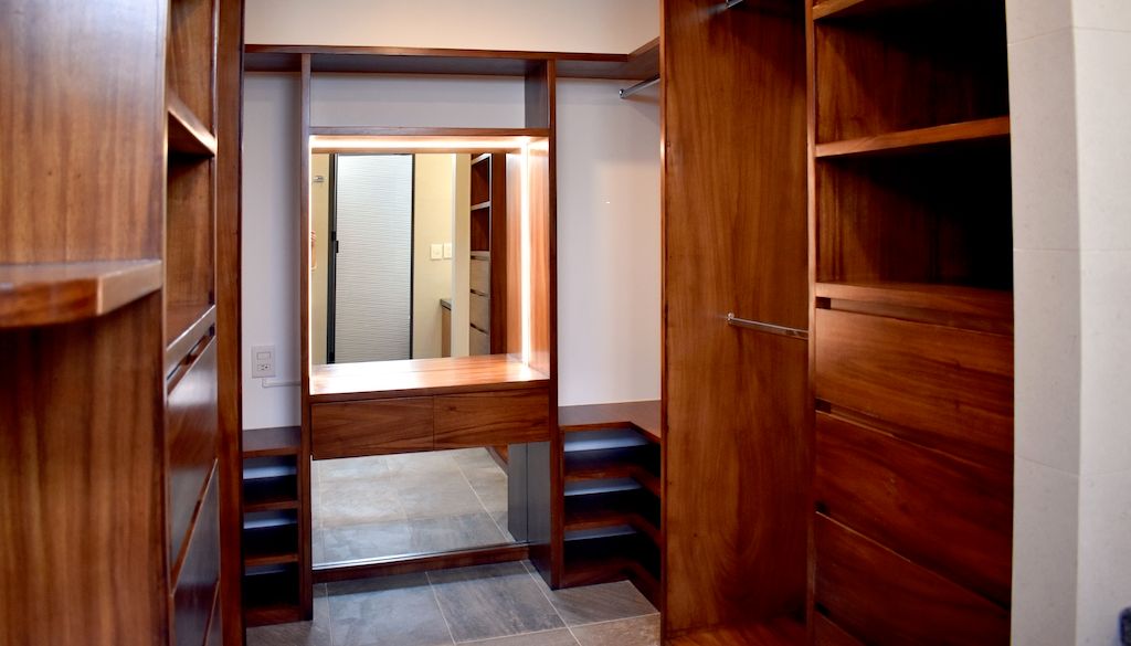 walk in closet with wood shelving and mirror