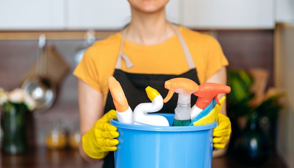 professional house cleaner holding bucket of supplies