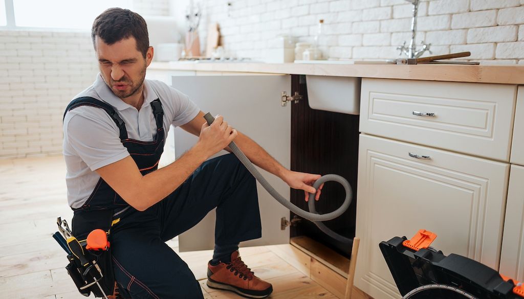 how to know if pipes are frozen: plumber catching bad smell while working