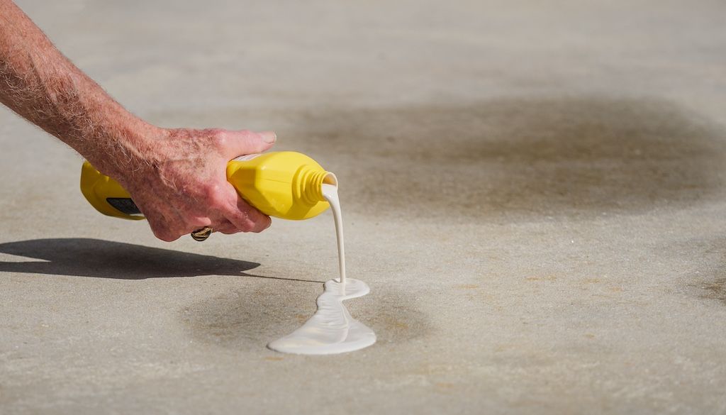 pouring driveway cleaning stain removal on driveway