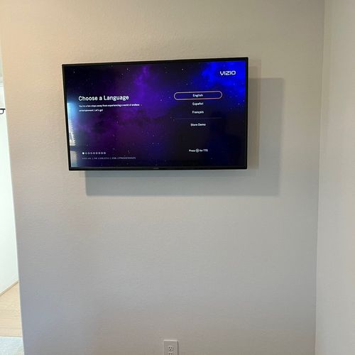 The TV mounted in the center of the wall and plugg