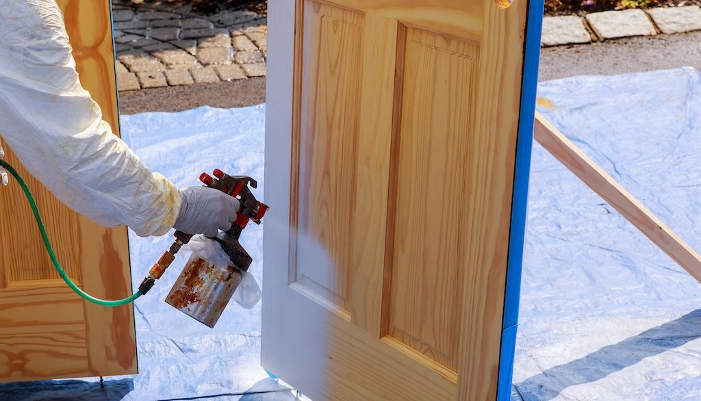 painter spray painting a door