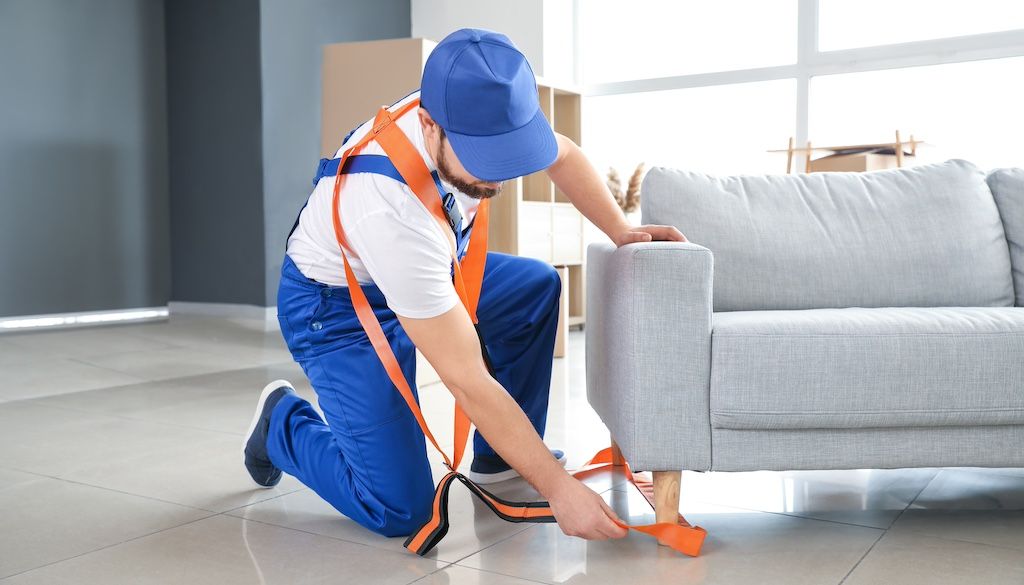 mover putting moving straps under couch