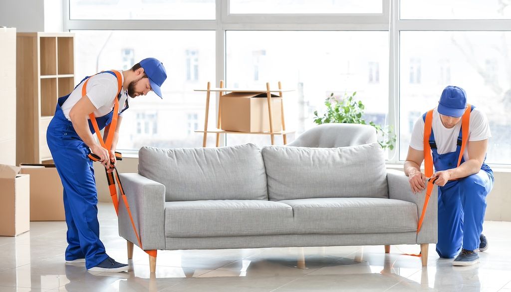 movers putting down couch and removing moving straps