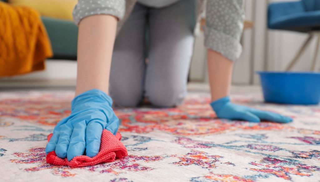 woman cleaning oriental rug with sponge