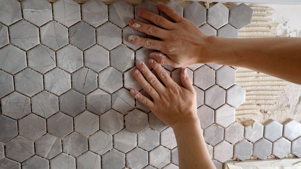 applying ceramic tile on bathroom wall