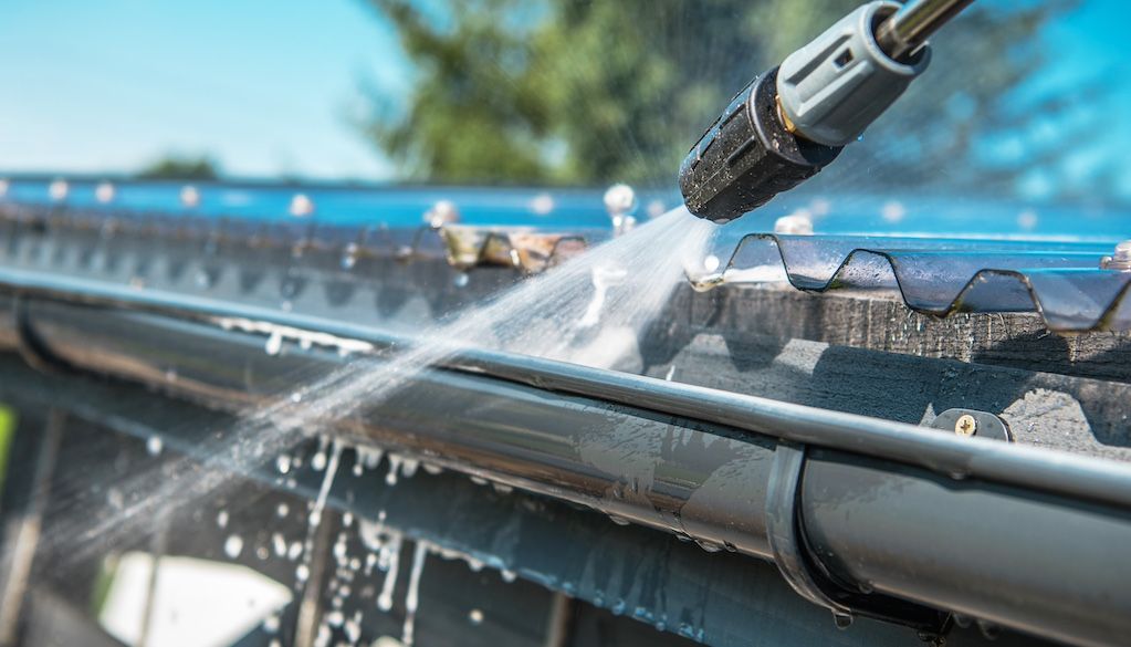 pressure washing gutters on a house