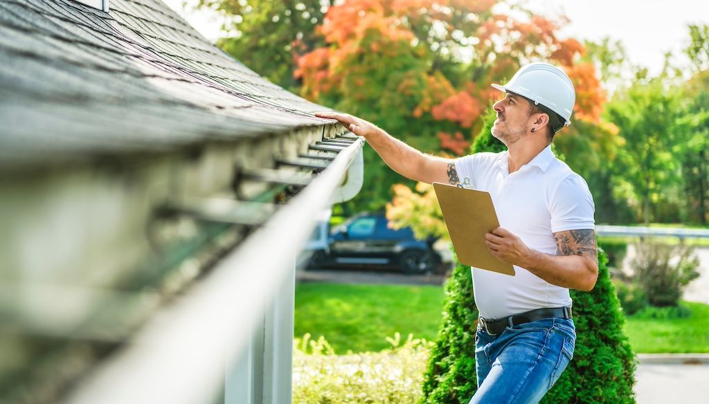 man inspecting roof to ensure it's walkable for gutter cleaning