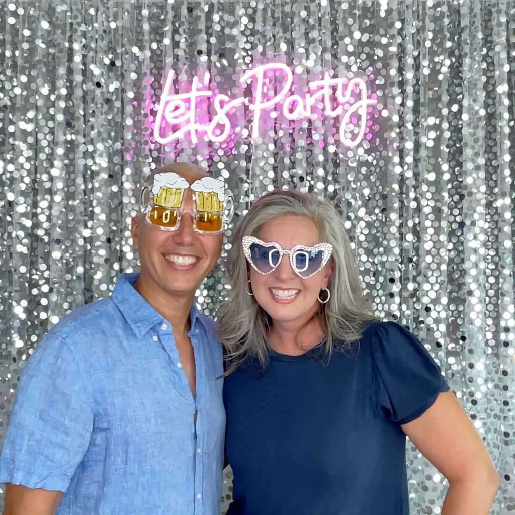 Photo booth with silver backdrop and "Let's Party"