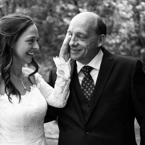 Bride wipes a tear from her dad's eye during first