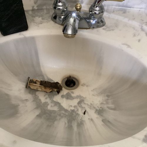 Removing debris from bathroom sink.